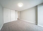 Thumbnail 40 of 47 - a bedroom with white walls and carpet and white cabinets