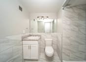 Thumbnail 38 of 47 - a bathroom with a toilet and a sink and a shower