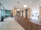 Thumbnail 8 of 47 - a large lobby with a wooden reception desk and glass walls