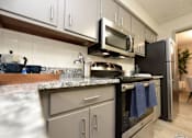 Thumbnail 3 of 18 - a kitchen with stainless steel appliances and granite counter tops