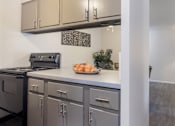 Thumbnail 7 of 10 - A modern kitchen with a stove, oven, and cabinets.