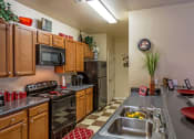 Thumbnail 13 of 16 - Kitchen area with black appliances