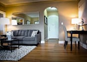 Thumbnail 25 of 66 - Living room with couch, desk, and arched doorway