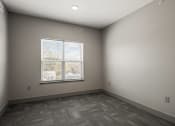 Thumbnail 14 of 18 - an empty room with a window and wood flooring