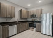 Thumbnail 1 of 18 - a kitchen with wooden cabinets and stainless steel appliances