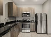 Thumbnail 2 of 18 - a kitchen with stainless steel appliances and wooden cabinets