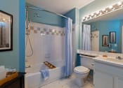 Thumbnail 3 of 26 - A blue bathroom with a white toilet and a white sink.