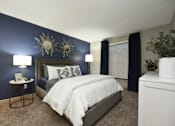 Thumbnail 7 of 18 - a bedroom with a blue accent wall and a white bed