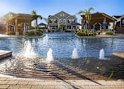 Thumbnail 10 of 37 - A fountain in the middle of a pool surrounded by houses.
