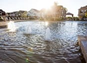Thumbnail 9 of 37 - A fountain in the middle of a pool surrounded by houses.