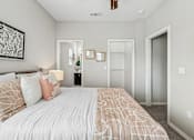 Thumbnail 26 of 37 - A bedroom with a large bed and a ceiling fan.