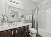 Thumbnail 30 of 37 - A white bathroom with a toilet, sink, and mirror.