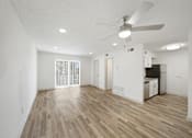Thumbnail 9 of 14 - A room with a ceiling fan and wooden flooring.