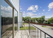 Thumbnail 5 of 14 - A balcony with a view of a street and trees.