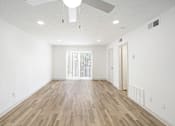 Thumbnail 12 of 14 - A room with wooden flooring and a ceiling fan.