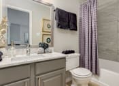 Thumbnail 25 of 25 - A bathroom with a toilet, sink, and shower curtain.