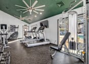 Thumbnail 5 of 25 - A gym with treadmills, weights, and exercise equipment.