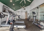 Thumbnail 6 of 25 - A gym with treadmills and elliptical machines.