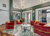 Thumbnail 4 of 25 - A living room with red chairs and a glass table.