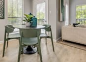 Thumbnail 19 of 25 - A dining room with a green table and chairs.