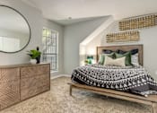 Thumbnail 21 of 25 - A bedroom with a bed, dresser, and mirror.