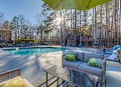 Thumbnail 1 of 25 - A sunny day at the poolside with a yellow umbrella providing shade.