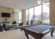 Thumbnail 12 of 47 - a pool table in the lobby of a building with large windows