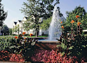 Thumbnail 6 of 12 - a fountain in the middle of a park with flowers at Village Club on Franklin, Southfield, 48034