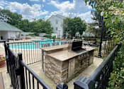 Thumbnail 7 of 12 - a patio with a grill and a swimming pool at Village Club on Franklin, Southfield