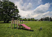 Thumbnail 14 of 47 - a playground with a slide and a bench in a park at Village Club of Rochester Hills, Shelby Township Michigan