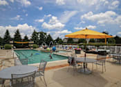 Thumbnail 20 of 47 - a swimming pool with tables and umbrellas and people in it at Village Club of Rochester Hills, Shelby Township, 48317