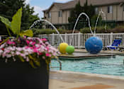 Thumbnail 31 of 47 - a swimming pool with water sprinklers and a house in the background at Village Club of Rochester Hills, Michigan, 48317