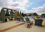 Thumbnail 11 of 47 - a pool with lounge chairs and a water fountain at Village Club of Rochester Hills, Shelby Township, MI 48317