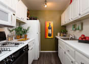 Thumbnail 1 of 47 - a kitchen with white cabinets and a stove and a refrigerator at Village Club of Rochester Hills, Shelby Township, MI