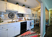 Thumbnail 43 of 47 - a kitchen with white cabinets and a clock on the wall at Village Club of Rochester Hills, Shelby Township, MI 48317