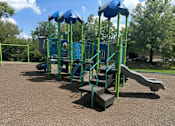 Thumbnail 16 of 16 - A playground with a green and blue slide and a blue canopy.