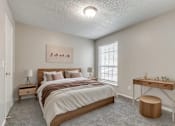 Thumbnail 4 of 50 - A bedroom with a bed, desk, and window.
