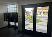 Thumbnail 22 of 23 - A black door with a glass window showing a street view.