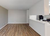 Thumbnail 5 of 13 - A room with wooden flooring and white walls.
