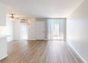 Thumbnail 8 of 13 - A room with wooden flooring and white walls.
