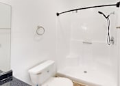 Thumbnail 12 of 23 - A white bathroom with a toilet, sink, and shower.
