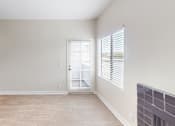 Thumbnail 6 of 23 - A room with a door and a window with blinds.