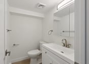 Thumbnail 8 of 33 - A white bathroom with a toilet, sink, and mirror.