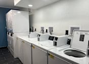 Thumbnail 15 of 23 - A row of washing machines in a laundromat.