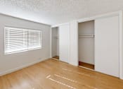 Thumbnail 5 of 12 - A room with wooden floors and white walls.