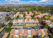 Thumbnail 36 of 37 - an aerial view of a neighborhood with orange roofs and a green field in the background