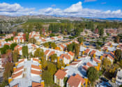 Thumbnail 31 of 37 - an aerial view of a neighborhood with orange roofs and a green hillside in the background