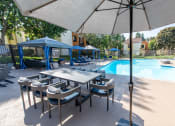 Thumbnail 14 of 37 - Pool view with dining furniture, cabanas, and sparkling pool