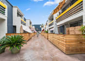 Thumbnail 11 of 14 - a courtyard with a wooden fence and planters on either side of it