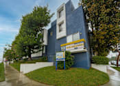 Thumbnail 2 of 14 - a blue building with a yellow and white sign in front of it